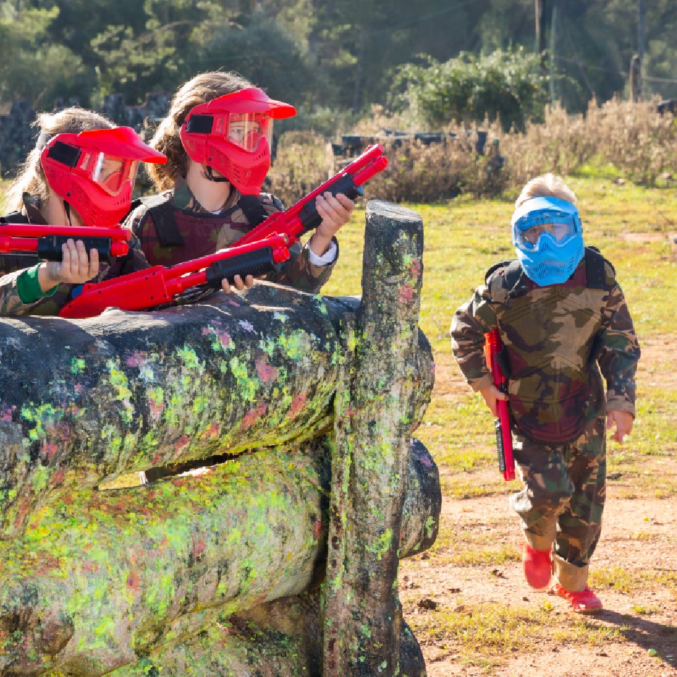 Adolescentes en una partida de airsoft con cascos de distintos colores